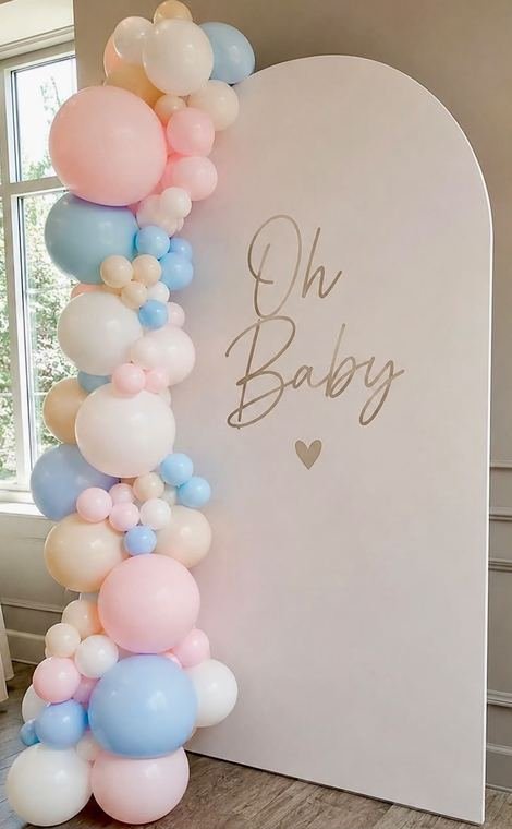 Cream arch backdrop with a pastel pink, blue and cream balloon garland and Oh Baby lettering
