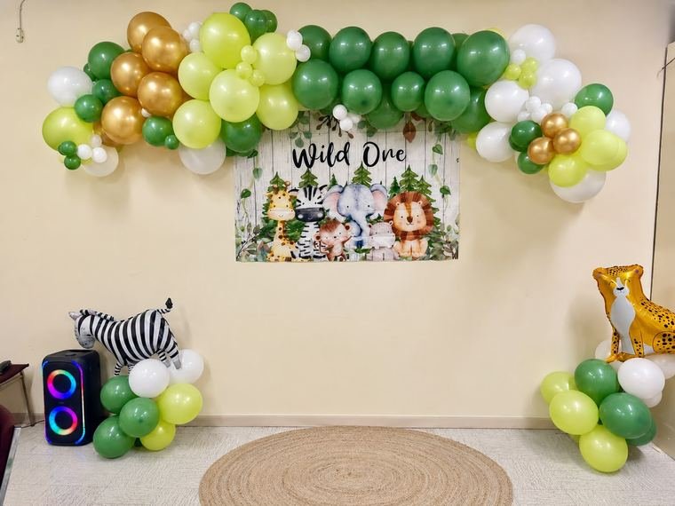 Wild One safari themed balloon garland in greens and gold