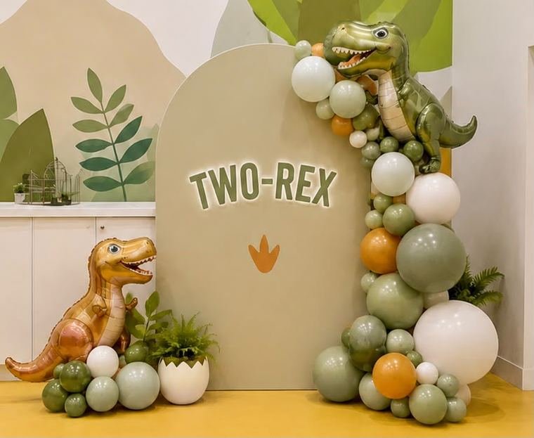 Two-Rex dinosaur themed second birthday backdrop with sage and orange balloons